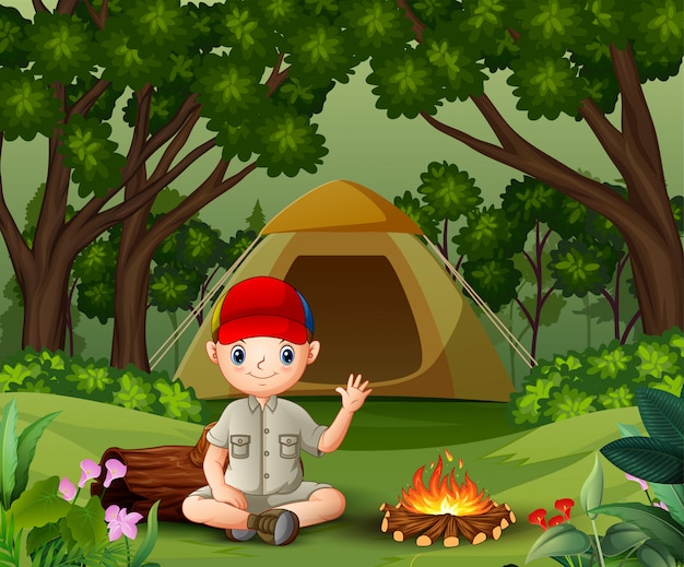 Boy Scout sentado cerca de la fogata