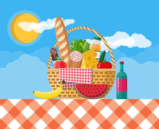 Cesta de picnic de mimbre llena de productos.