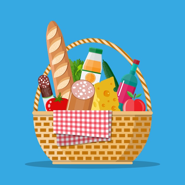 Cesta de picnic de mimbre llena de productos.