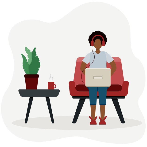Chica de ébano con auriculares rojos con una laptop que trabaja desde casa. Chica en un sillón rojo con una taza.