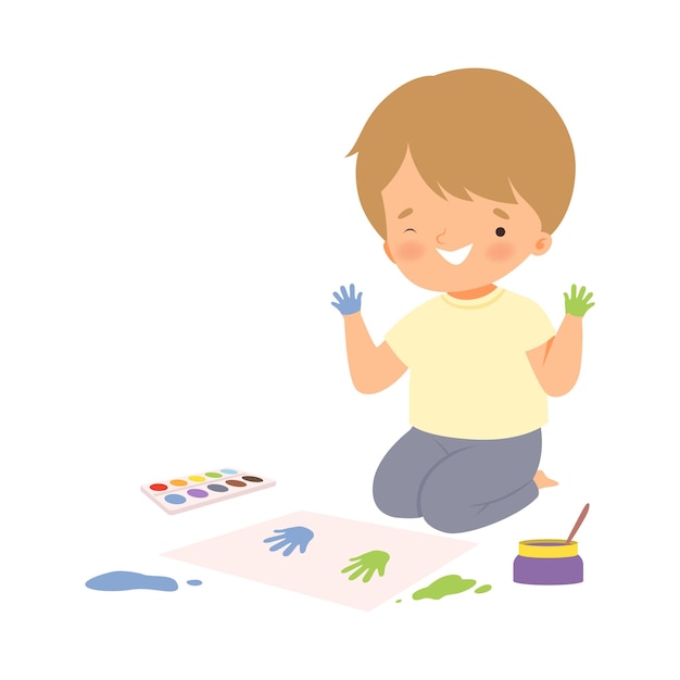 Vector chico lindo sentado en el suelo pintando con huellas de manos coloridas adorable joven artista de dibujos animados