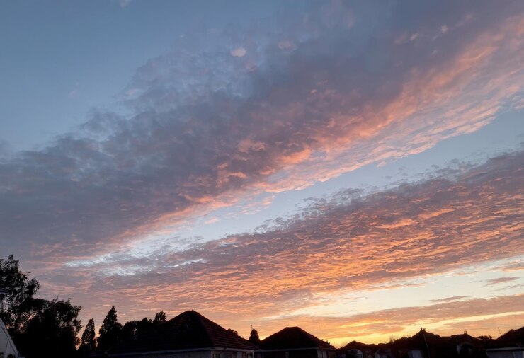 Vector un cielo con algunas nubes y una puesta de sol de fondo