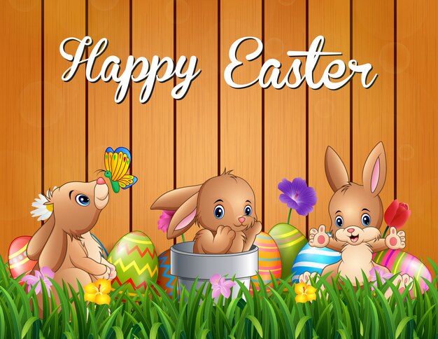 Conejitos de pascua felices en una cerca del fondo