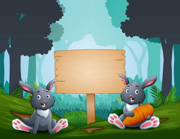 Los conejitos de pascua con un letrero de madera en el bosque