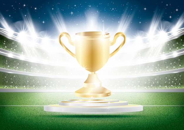 Copa de oro con focos en el estadio. Arena de fútbol con hierba verde.