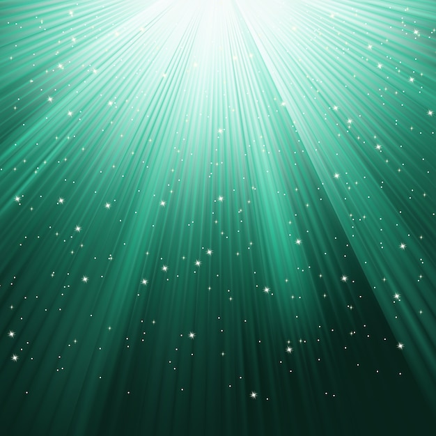 Los copos de nieve y las estrellas descendiendo en un camino de luz verde. archivo incluido