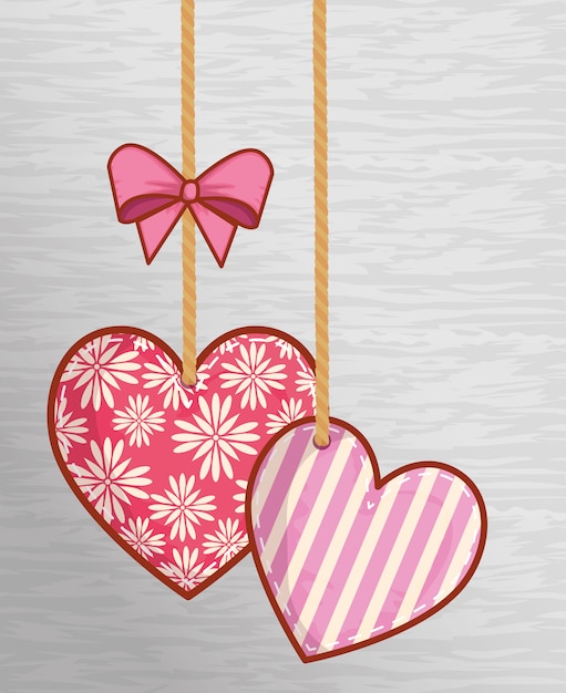 Vector corazones que cuelgan con lazo de cinta para la decoración del día de san valentín.