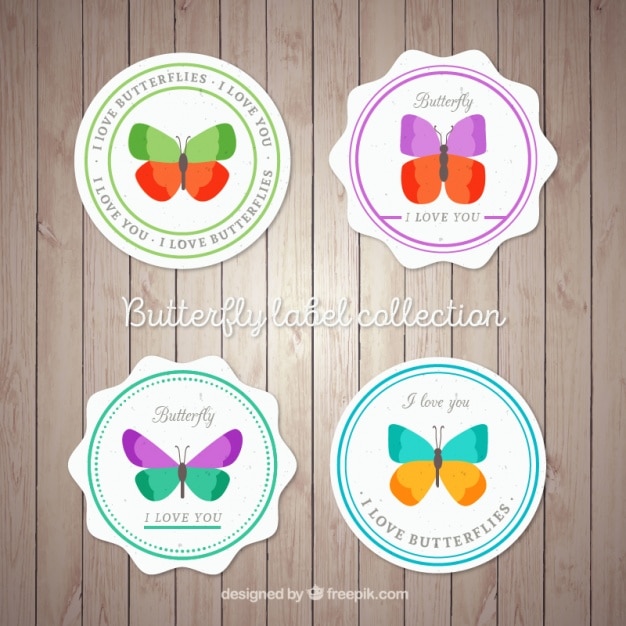 Vector cuatro insignias con mariposas sobre un fondo de madera