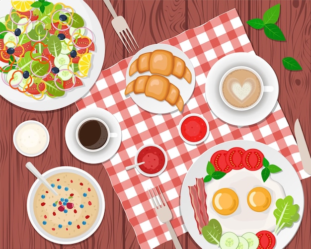 desayuno saludable en la mesa. Huevos fritos, café, ensalada, tostadas y croissants. Departamento