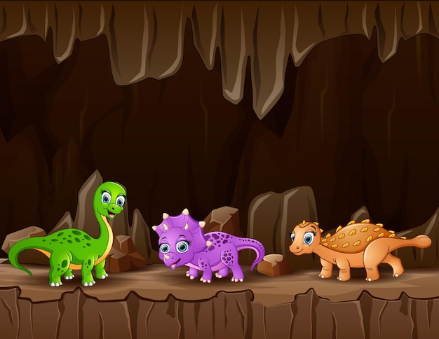 Vector dibujos animados de tres dinosaurios en la cueva oscura.