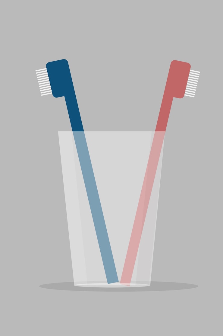 Vector dos cepillos de dientes en un vaso transparente sobre un fondo blanco.