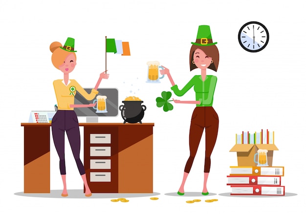 Dos jóvenes trabajadoras de oficina celebran el día de san patricio en el lugar de trabajo con jarras de cerveza, la bandera de irlanda en las manos