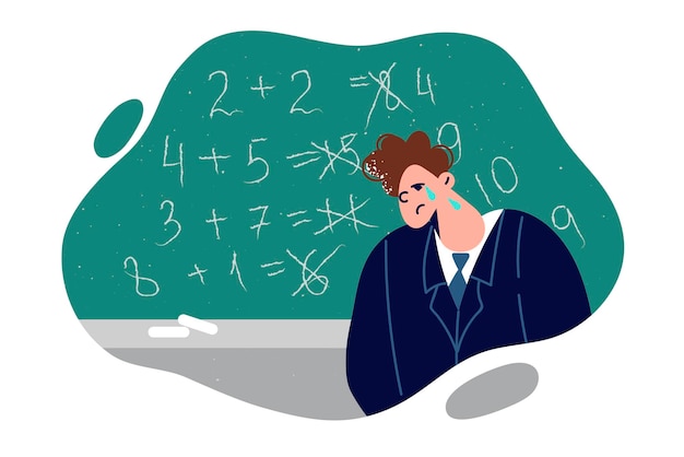 Un escolar está llorando de pie cerca de la pizarra con ejemplos matemáticos erróneos