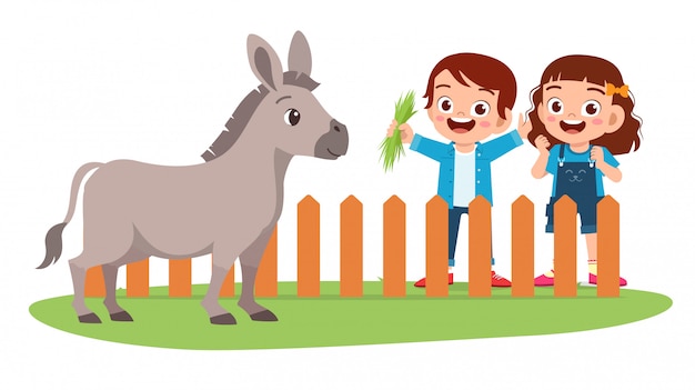 Feliz lindo niño niño y niña alimentan burro