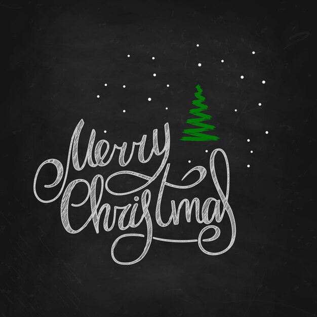 Feliz Navidad. Letras escritas a mano en una pizarra negra con un árbol de Navidad verde y copos de nieve. Año Nuevo 2022.