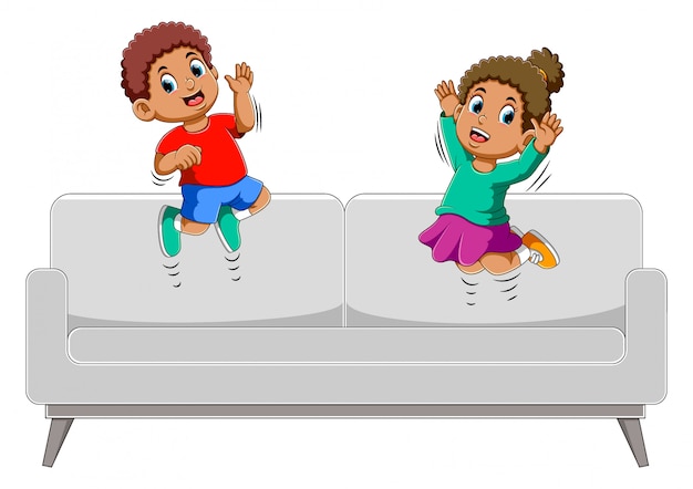 Feliz niño y niña saltando en el sofá