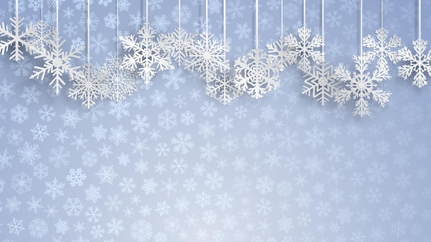 Fondo navideño con grandes copos de nieve blancos colgantes sobre fondo azul claro de pequeños copos de nieve