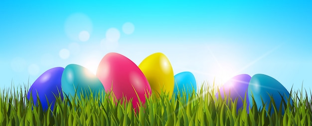 Fondo de Pascua con huevos coloridos en la hierba verde
