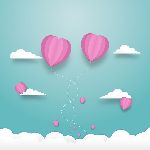 Globos de corazón volando en el cielo nublado