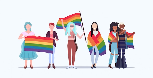 Grupo de mujeres sosteniendo la bandera del arco iris desfile del amor lgbt orgullo festival concepto mezclar raza lesbiana abrazando personajes de dibujos animados femeninos de pie juntos longitud completa plana horizontal