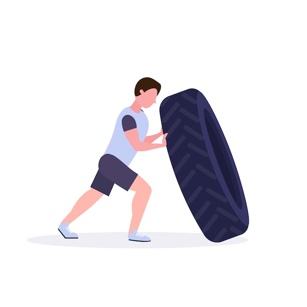Hombre deportivo volteando un neumático haciendo ejercicios duros chico trabajando en el gimnasio crossfit entrenamiento concepto de estilo de vida saludable fondo blanco