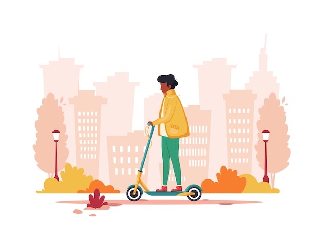 Hombre negro montando patinete eléctrico en otoño. Concepto de transporte ecológico.