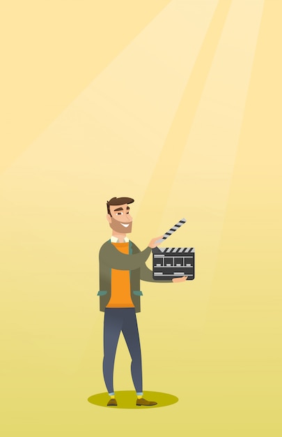 Hombre sonriente que sostiene un clapperboard abierto.