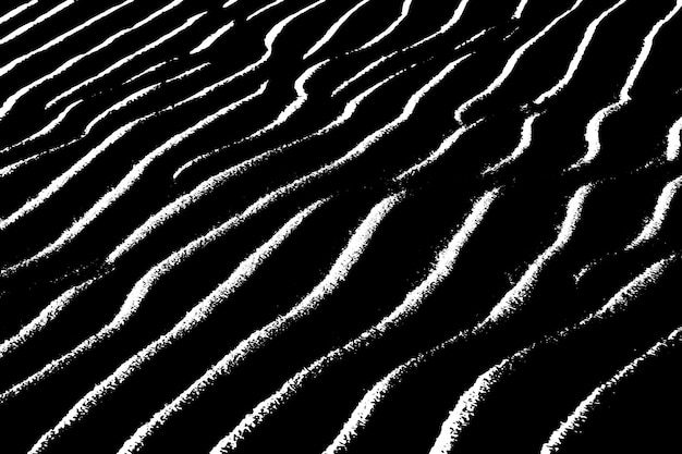 Una imagen en blanco y negro de ondas en la arena.