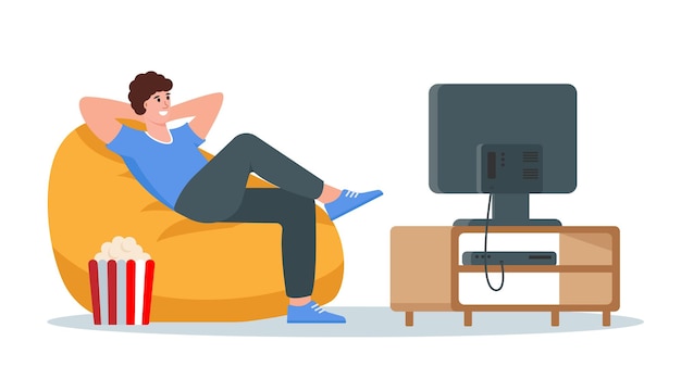 Joven relajado sentado en un sillón y viendo la televisión.