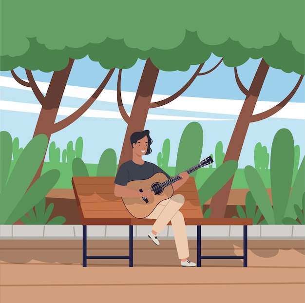 El joven sentado en el banco y tocando la guitarra acústica en el parque.