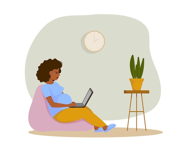 Linda mujer embarazada trabajando desde casa con una computadora portátil mientras está sentada en una silla de bolsa