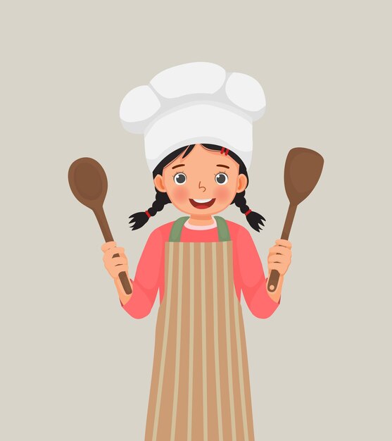 Linda niñita con sombrero de chef y delantal sosteniendo espátula de utensilio de cocina y cuchara de cucharón