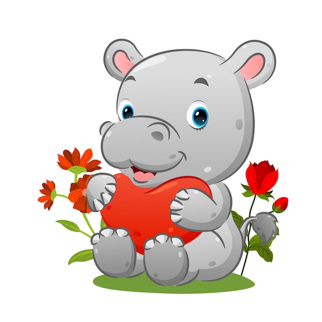 El lindo hipopótamo está sentado en la hierba y sostiene el globo del corazón en el jardín de la ilustración.