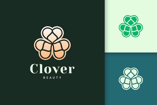 El logotipo de la hoja de trébol en color dorado de lujo representa la suerte o la hierba.