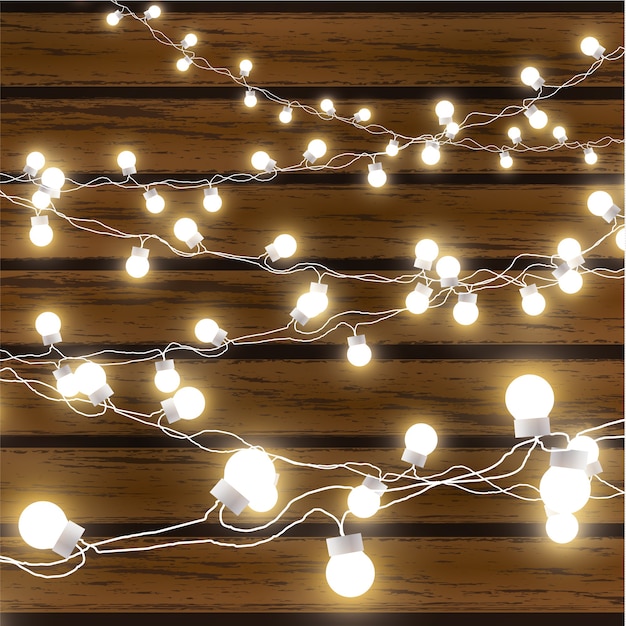 Luces de Navidad aisladas sobre fondo de madera oscura. Bombillas de guirnalda incandescente en cables.