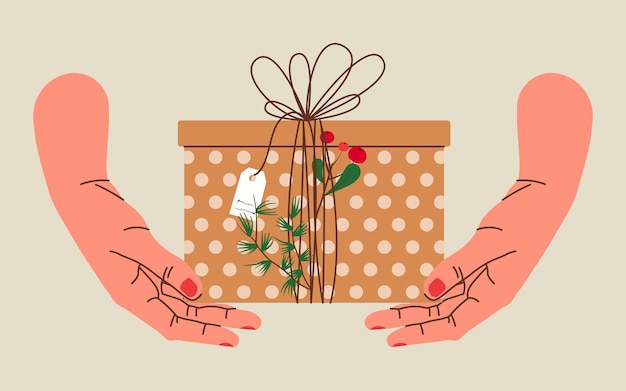 Manos sosteniendo regalo de navidad en papel kraft con etiqueta y bayas. caja de regalo en envoltorio artesanal.