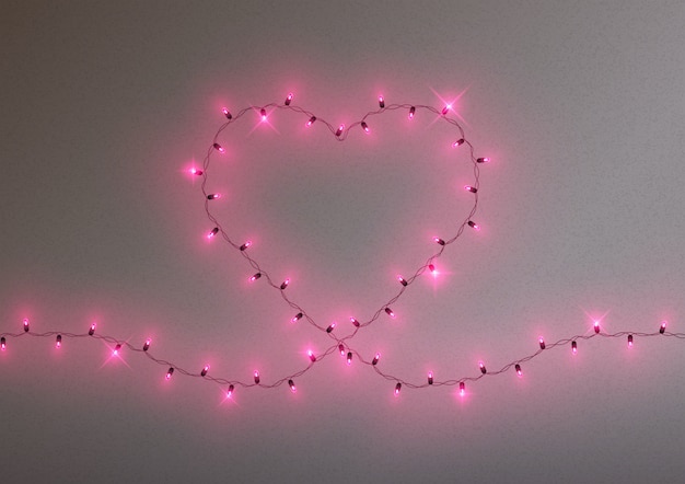 Vector marco de guirnalda de luces led en forma de corazón brillante