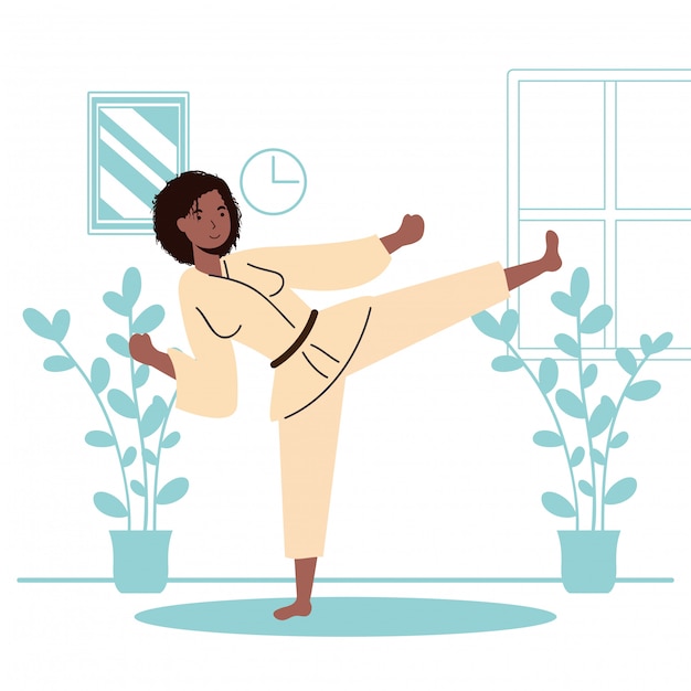 Mujer afro practicando actividad deportiva de karate en la casa