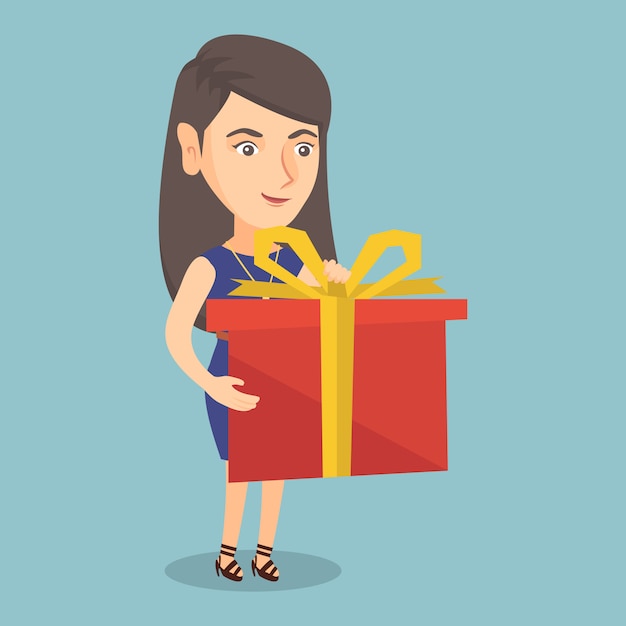 Mujer caucásica joven que sostiene una caja con el regalo.