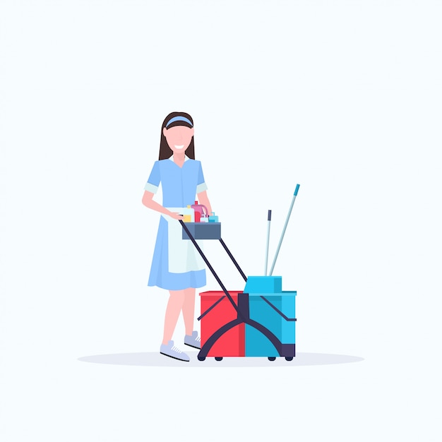 Mujer criada con carro carro con suministros conserje limpiador femenino en concepto de servicio de limpieza uniforme de cuerpo entero