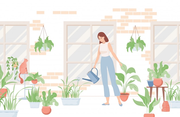 Mujer que sostiene la regadera y que riega las plantas caseras cerca de la casa o en el cuarto.