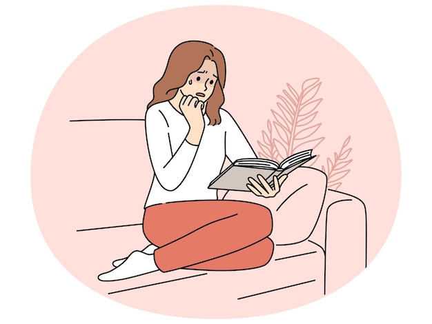 Mujer sentada en el sofá leyendo un libro llorando