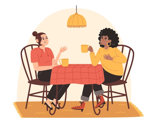 Las mujeres jóvenes están sentadas en la mesa de la cocina y divirtiéndose hablando.