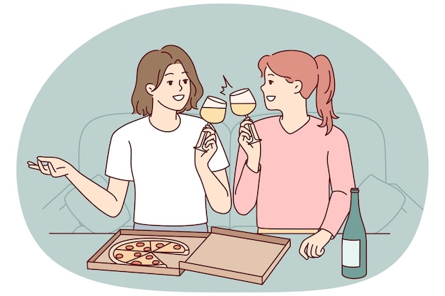 Mujeres jóvenes felices sentadas en el sofá en casa comiendo pizza bebiendo vino chicas sonrientes