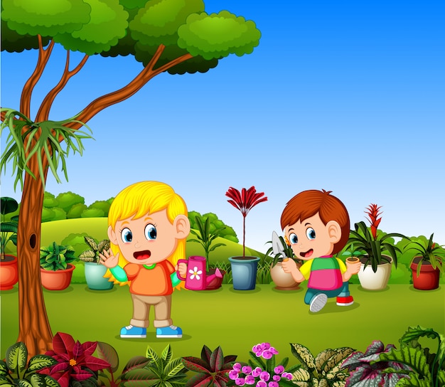 Niña regando plantas y un niño plantando en un jardín