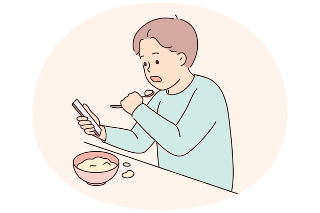 Niño come viendo dibujos animados en el teléfono celular