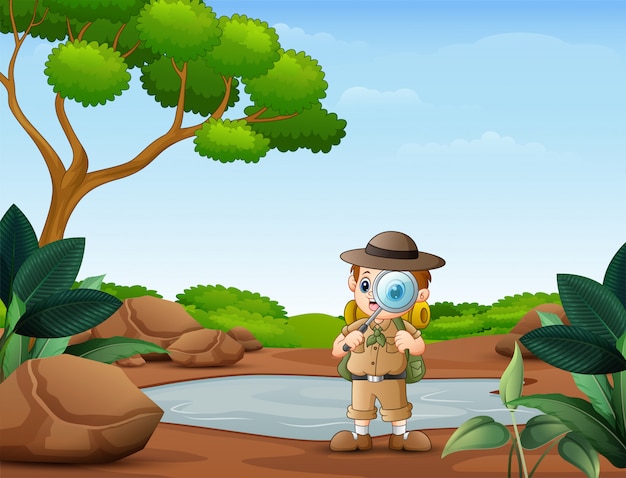 El niño explorador con lupa en la naturaleza.