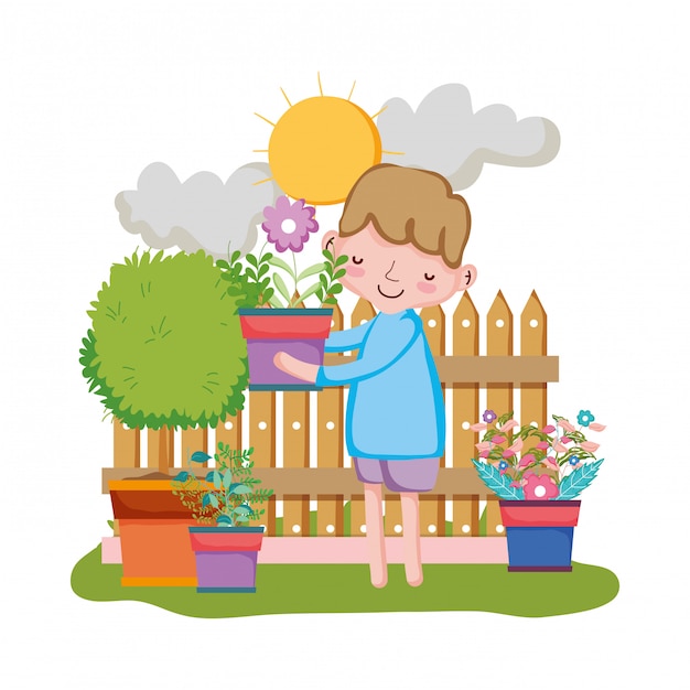 Niño levantando planta de interior con valla en el jardín