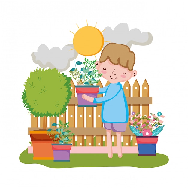 Niño levantando planta de interior con valla en el jardín