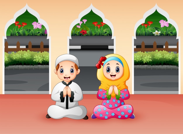 Niño y niña musulmanes rezan en la mezquita